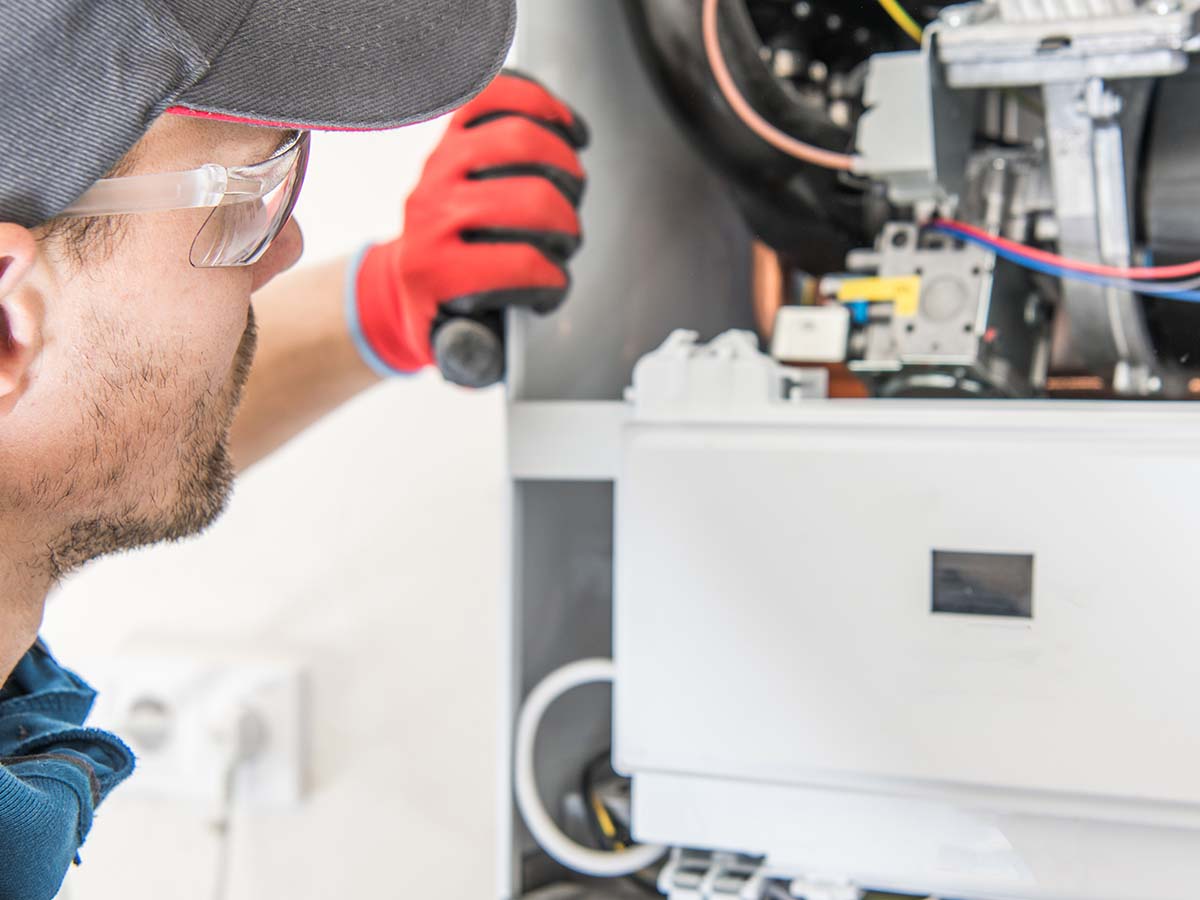 man servicing a furnace