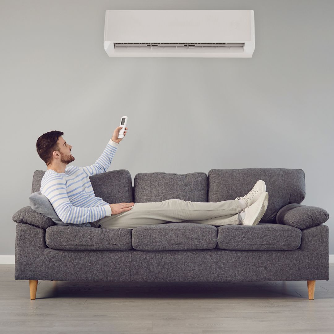 person on couch controlling air conditioning 