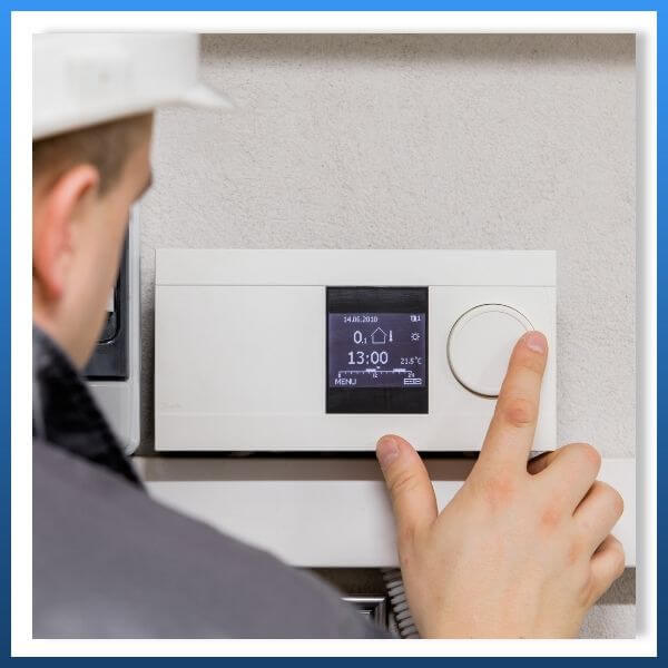HVAC tech working on thermostat
