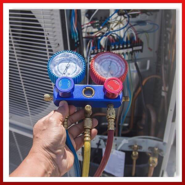 HVAC tech checking refrigerant in air conditioner