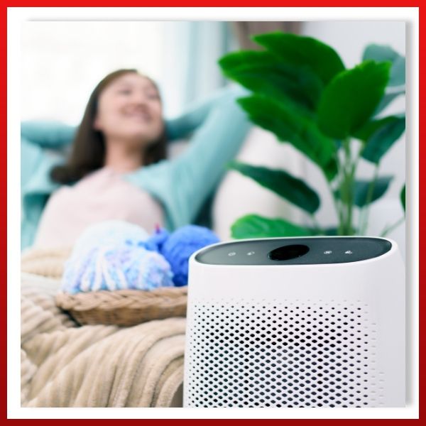 a woman relaxing near an air purifier