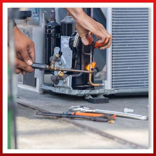 HVAC technician repairing AC unit